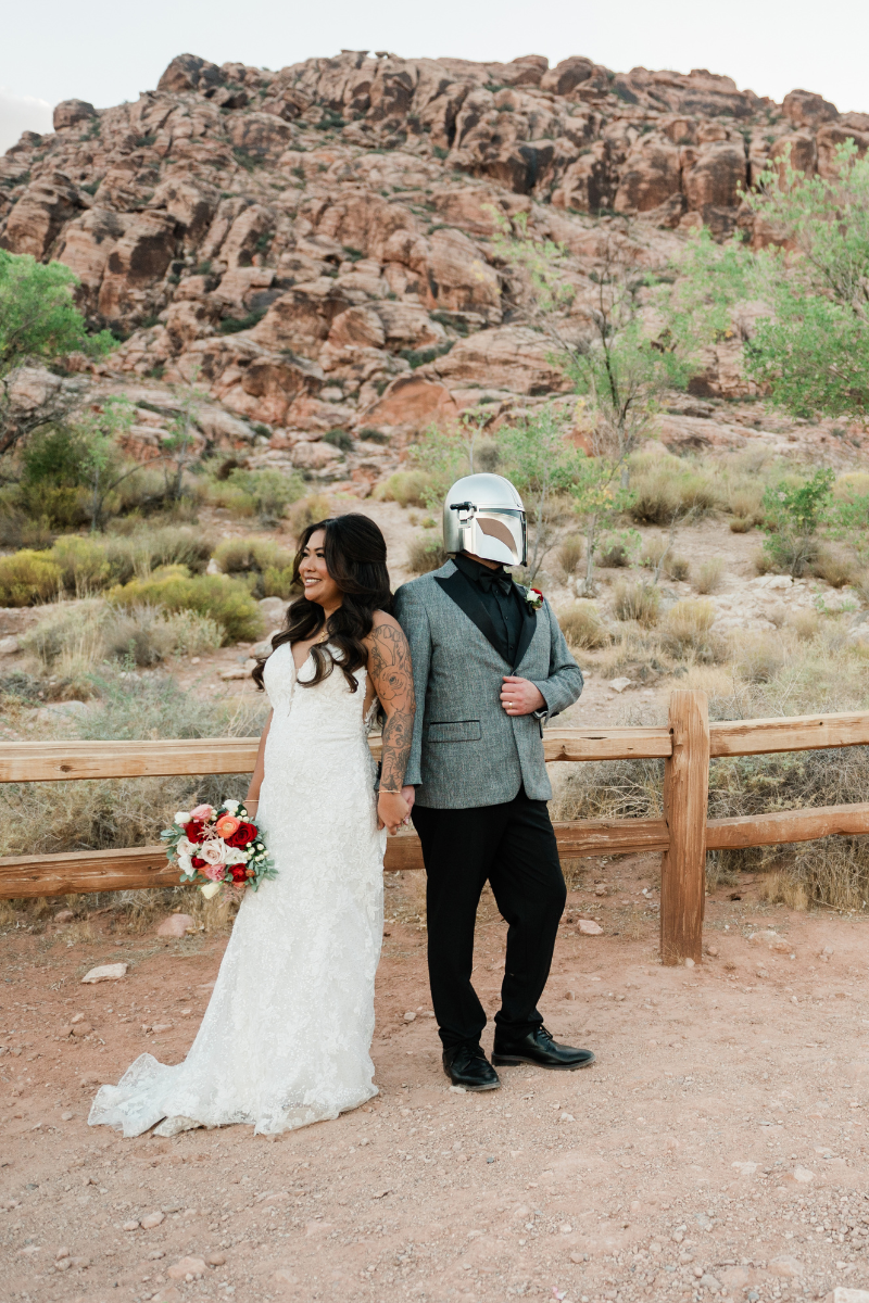 a bride and groom at red rock canyon. the groom wears a star wars style helmet.